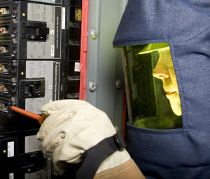 Electrician suited in PPE working on live equipment